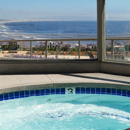 A luxurious resort pool with a clear blue sky, palm trees, and lounge chairs; serene water, decorative umbrellas, and a sunny vacation vibe.